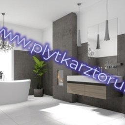 Paweł Kowal - Nowoczesna łazienka z wolnostojącą wanną, szarą ścianą, podwieszaną szafką z umywalką, lustrem i toaletą w minimalistycznym stylu, oświetlona przez wiszące lampy i żyrandol.