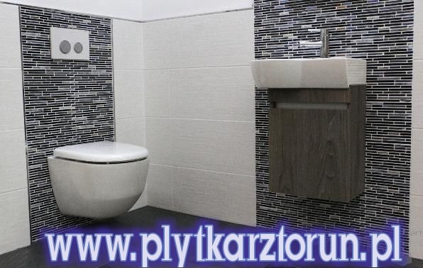 Nowoczesna łazienka z wiszącą toaletą i umywalką na szafce, ściany wyłożone białymi płytkami oraz mozaiką w odcieniach szarości i czerni.