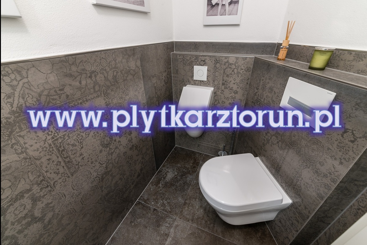 Nowoczesna, mała toaleta w szaro-brązowych płytkach z orientalnym wzorem, wisząca muszla klozetowa i bidet, minimalistyczny design, dekoracyjny dyfuzor zapachowy na półce.