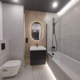 ROMAN MATUSHCHAK ARMBUILDING - Nowoczesna łazienka z podświetlanym lustrem, umywalką na szafce, toaletą podwieszaną i wanną z czarną armaturą. Płytki imitujące marmur i drewno. Ciemny sufit.