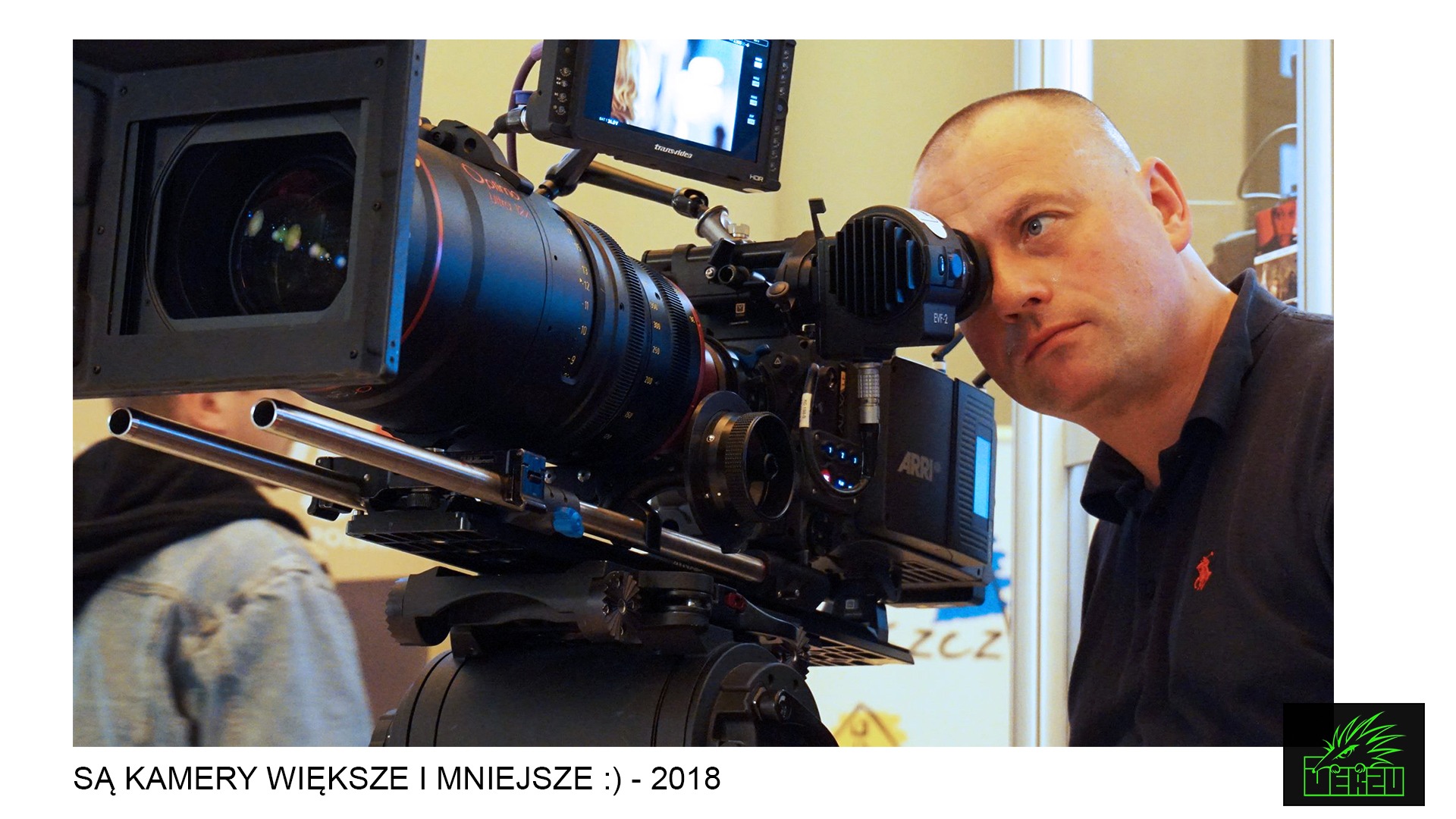 Kamerzysta patrzy przez wizjer kamery filmowej ARRI z dużym obiektywem Optimo Ultra 12x, obok monitor Transvideo HDR.
