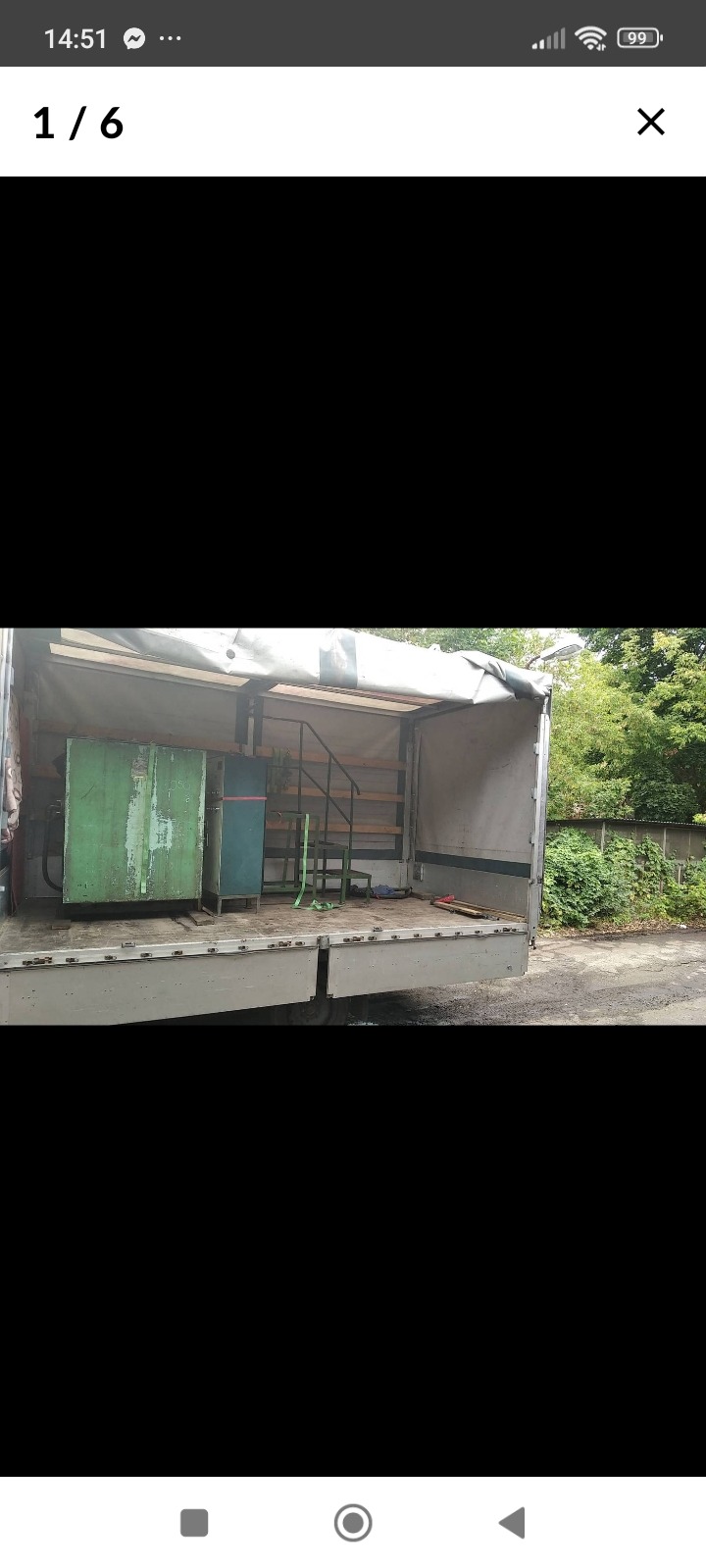 Wnętrze otwartej skrzyni ładunkowej samochodu dostawczego z załadowanymi meblami i metalowymi schodami, zabezpieczonymi pasami.