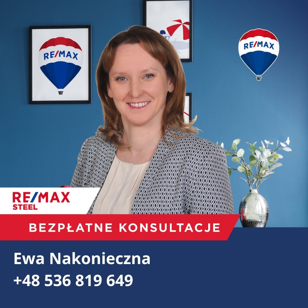 Portret uśmiechniętej kobiety w biurze agencji nieruchomości RE/MAX z logo firmy na ścianie i informacją o bezpłatnych konsultacjach.