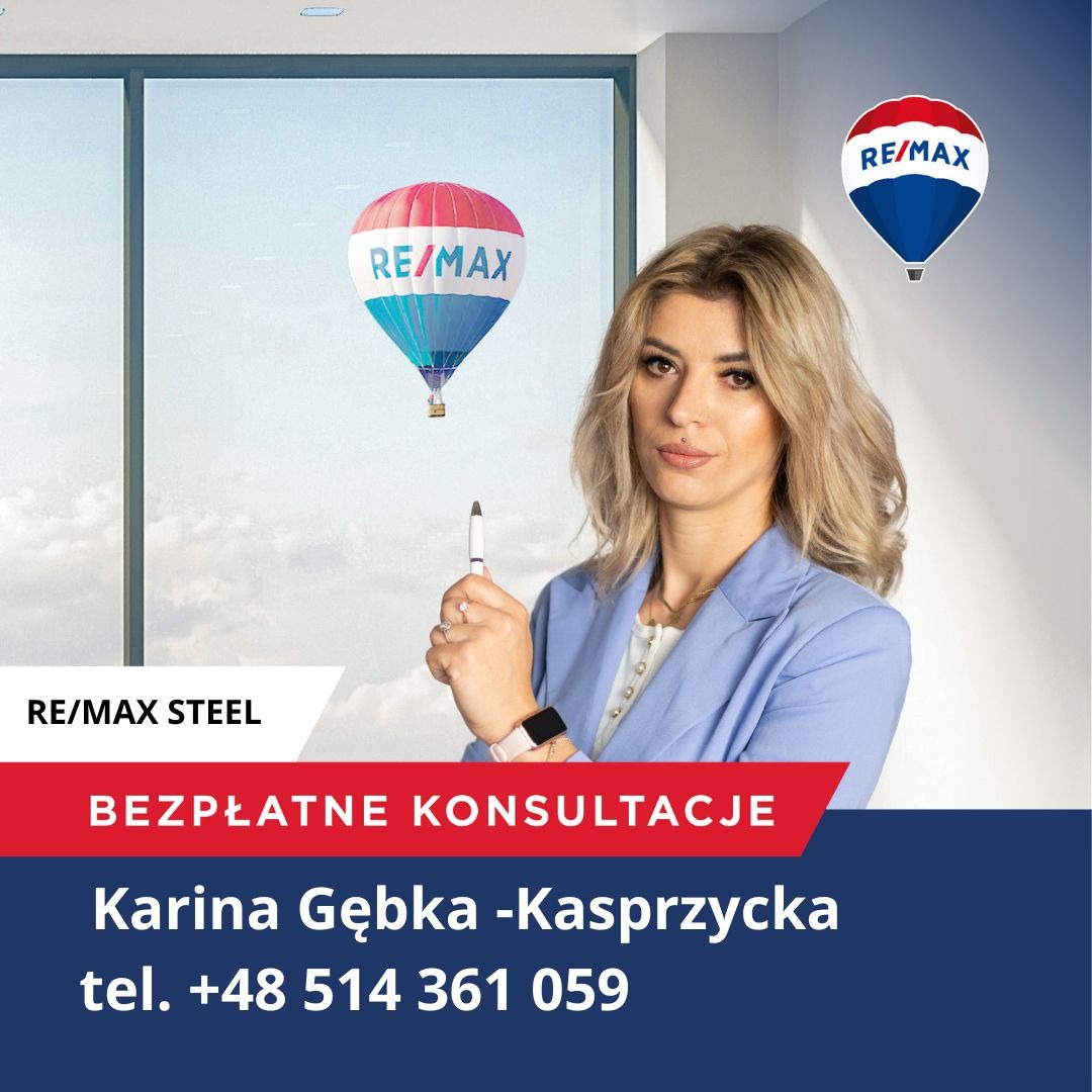 Portret kobiety w niebieskiej marynarce z długopisem w dłoni na tle okna z naklejką balonu RE/MAX i logo firmy RE/MAX STEEL.