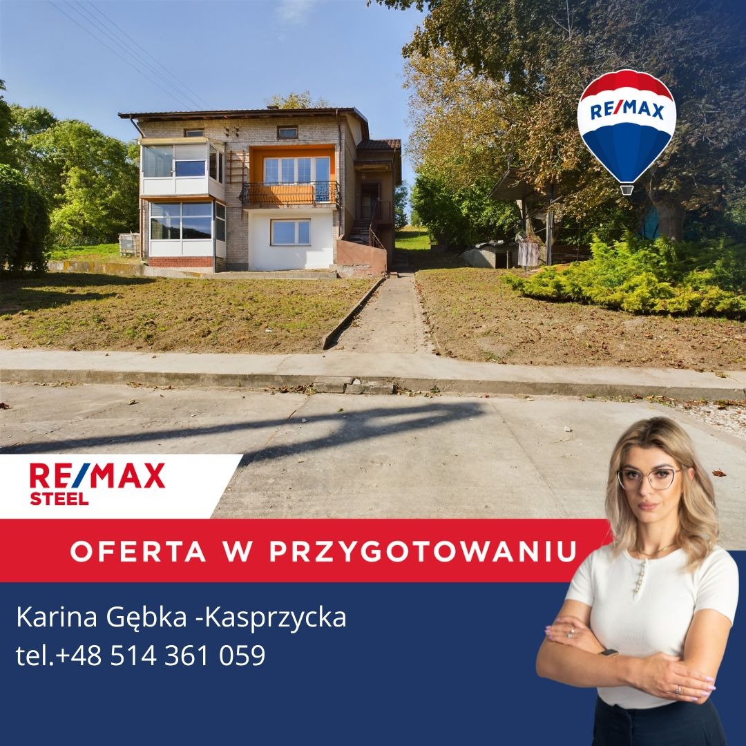 Dwupiętrowy dom z cegły z balkonem, logo RE/MAX w rogu, informacja o ofercie i kontakt do agenta.