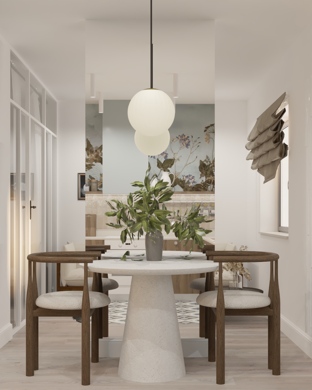 Jasna jadalnia z okrągłym stołem na postumencie, drewnianymi krzesłami z tapicerowanymi siedziskami, oraz wiszącą lampą kulistą; w tle widoczna kuchnia z tapetą w kwiaty.
