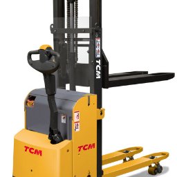 P.H. Agroma S.A. w Poznaniu - Żółto-szary wózek paletowy elektryczny marki TCM na białym tle, widok z boku. Widoczna konstrukcja masztu z łańcuchem i zabezpieczeniem, dyszel sterujący i palety.