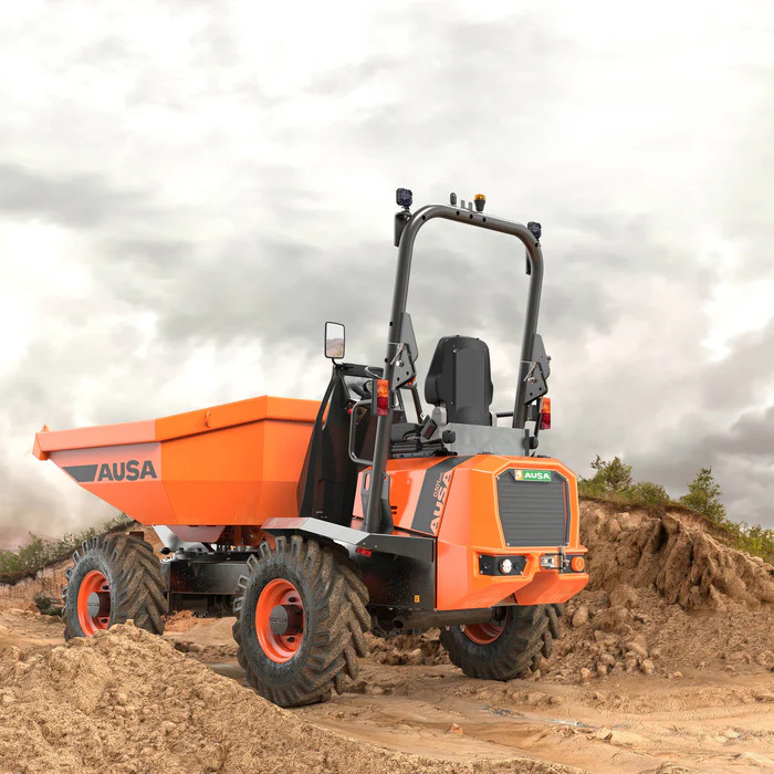 Pomarańczowy wozidło budowlane AUSA, widok z tyłu, na placu budowy w Kobylnicy, z widocznym logiem producenta.