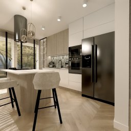 MM PROJEKT Małgorzata Mrozińska - Wizualizacja nowoczesnej kuchni z wyspą, krzesłami barowymi z tapicerką w odcieniach szarości, czarną lodówką i piekarnikiem, drewnianą podłogą w jodełkę oraz dużym oknem z żaluzjami.