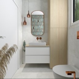 Marek Michalski - Wizualizacja łazienki z umywalką nablatową, owalnym lustrem z mozaiką, wiszącą toaletą i elementami dekoracyjnymi w odcieniach miedzi.