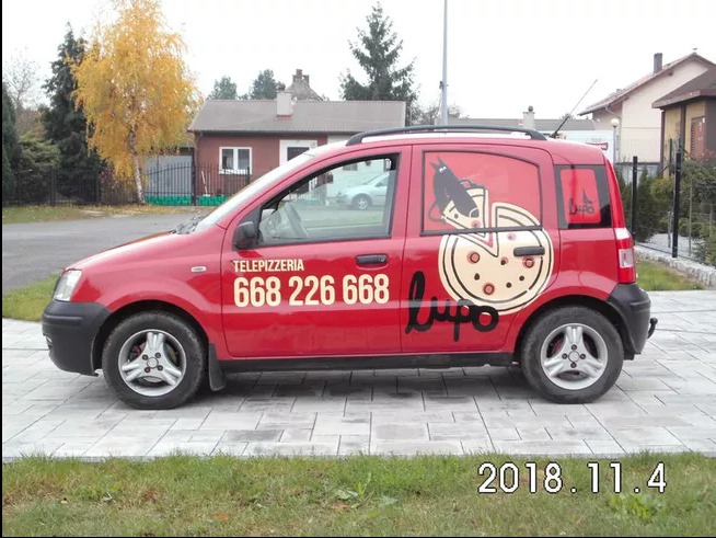 Czerwony samochód dostawczy z numerem telefonu 'Telepizzeria 668 226 668' i grafiką pizzy oraz logo 'Lupo'.