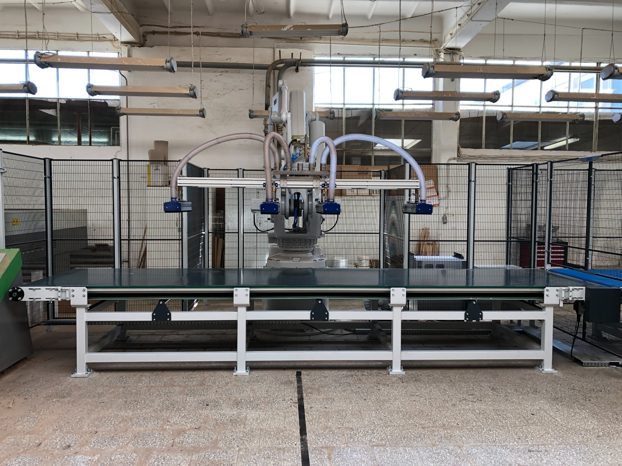 Stanowisko taśmociągu z manipulatorami do pobierania materiałów. Manipulator zamontowany na robocie.