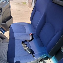 FRESHAUTO KAROL BOBRO - Wnętrze samochodu dostawczego: dwuosobowe siedzenie z niebieską tapicerką, widoczny pas bezpieczeństwa i otwarte drzwi kabiny.