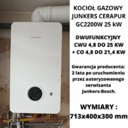 Biały, dwufunkcyjny piec gazowy Junkers Cerapur GC2200W 25 kW z widocznymi przyłączami hydraulicznymi i gazowymi, zamontowany na ścianie z widoczną instalacją.