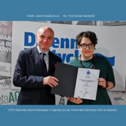 Iwona Piotrowska, logopeda, odbiera dyplom na Gali Hipokratesa Pomorza 2024 w Gdańsku, obok mężczyzna w garniturze trzyma czarną teczkę, w tle plakat Dziennika Bałtyckiego.