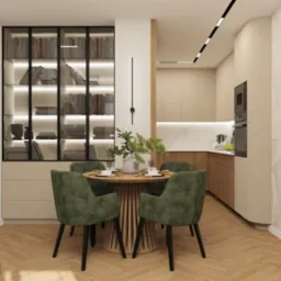 Nowoczesna aranżacja wnętrza: okrągły stół z zielonymi krzesłami, przeszklona biblioteczka z podświetleniem i widok na kuchnię w beżowo-brązowej tonacji.