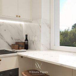 WIKTORIA FIGURA - Jasna kuchnia z marmurowym blatem i ścianą. Na blacie płyta indukcyjna, butelka octu i zioła w doniczce przy oknie. Minimalistyczny design z drewnianym stołkiem.