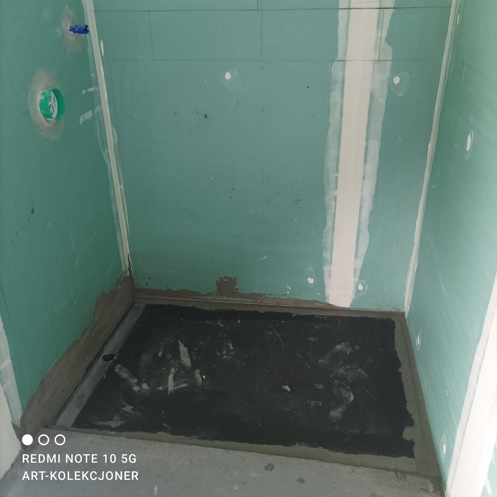 Przygotowanie brodzika w łazience: hydroizolacja na podłodze, ściany wykończone płytami kartonowo-gipsowymi z widocznymi otworami na instalacje.