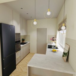 Pracownia Ładne Rzeczy Karolina Szczepanik - Jasna kuchnia z drewnianą podłogą w jodełkę, okrągłymi lampami i czarną lodówką Haier. Na blacie leżą cytryny. W tle okno z roletą.