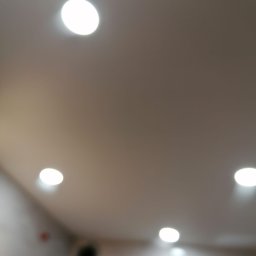 Usługi budowlane Wladysław Kliatskyi - Niejasne ujęcie sufitu z czterema punktowymi źródłami światła LED, widoczne elementy instalacji elektrycznej w tle.