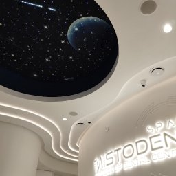 Concord Dmytro Hmyria - Recepcja w biurze z podświetlanym logo 'MISTODENT' i sufitem z motywem kosmosu: gwiazdy, księżyc i kometa