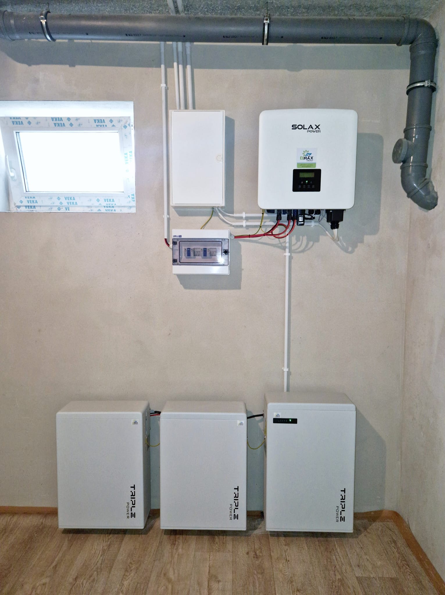 Instalacja magazynu energii Triple Power oraz falownika Solax w pomieszczeniu w Jabłonce, widoczne również zabezpieczenia i okablowanie.