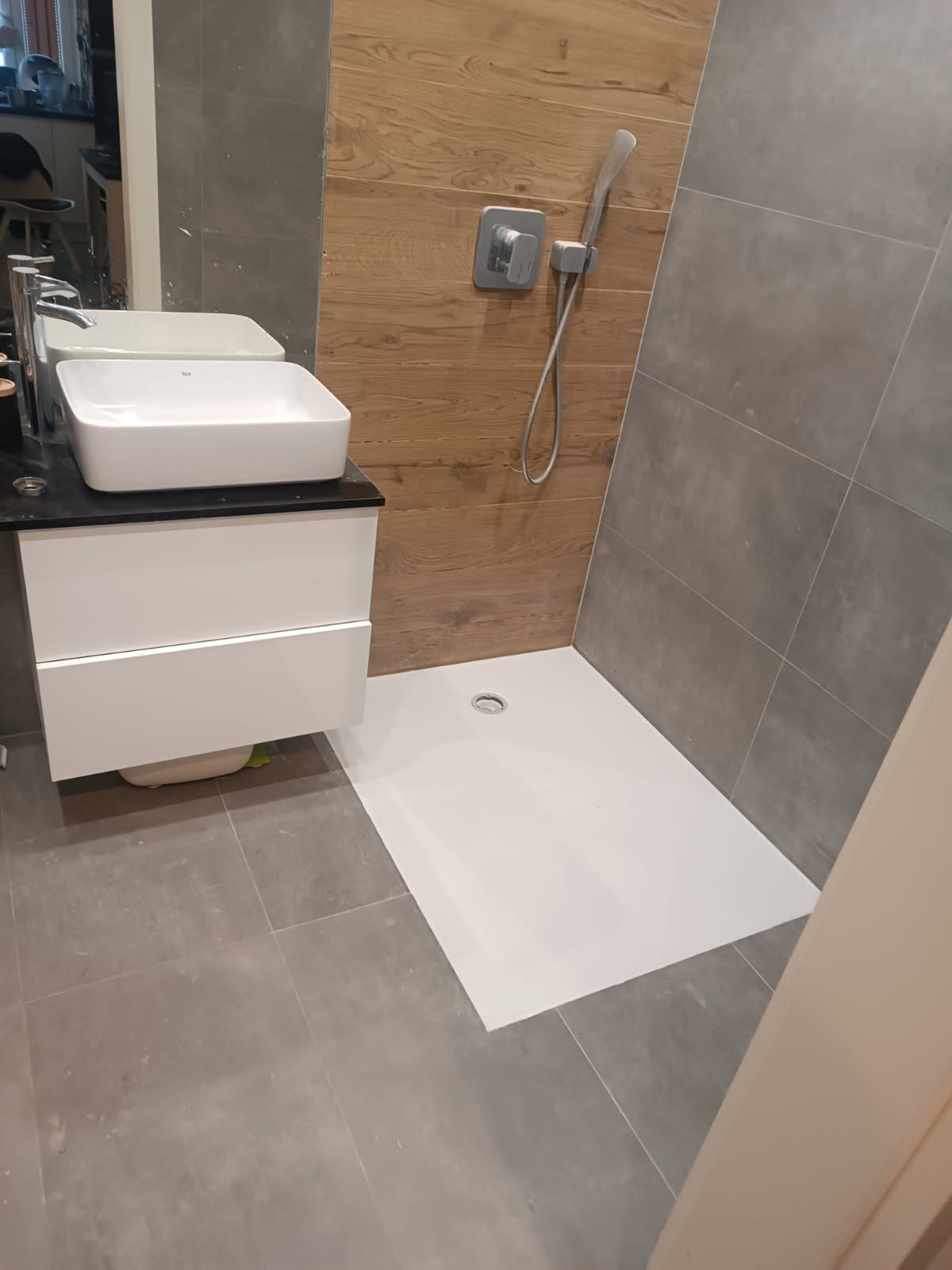 Nowoczesna łazienka z umywalką nablatową, kabiną prysznicową bez brodzika i płytkami imitującymi drewno na ścianie