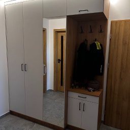 Antima - Nowoczesna szafa wnękowa z lustrem i oświetleniem LED, z częścią otwartą na ubrania i akcesoria, w przedpokoju z szarą podłogą.