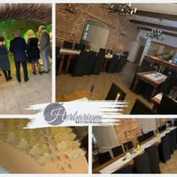 Sala restauracyjna z ceglanymi ścianami, przygotowana na przyjęcie, z ustawionymi stołami, czarnymi krzesłami, świecami i kieliszkami z napojem, widoczni goście w tle, logo restauracji wkomponowane...