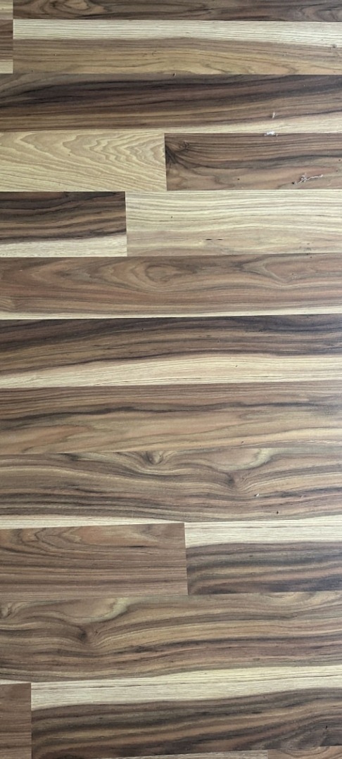 Ułożony parkiet z egzotycznego drewna o wyraźnym usłojeniu w odcieniach brązu i beżu, widok z góry.