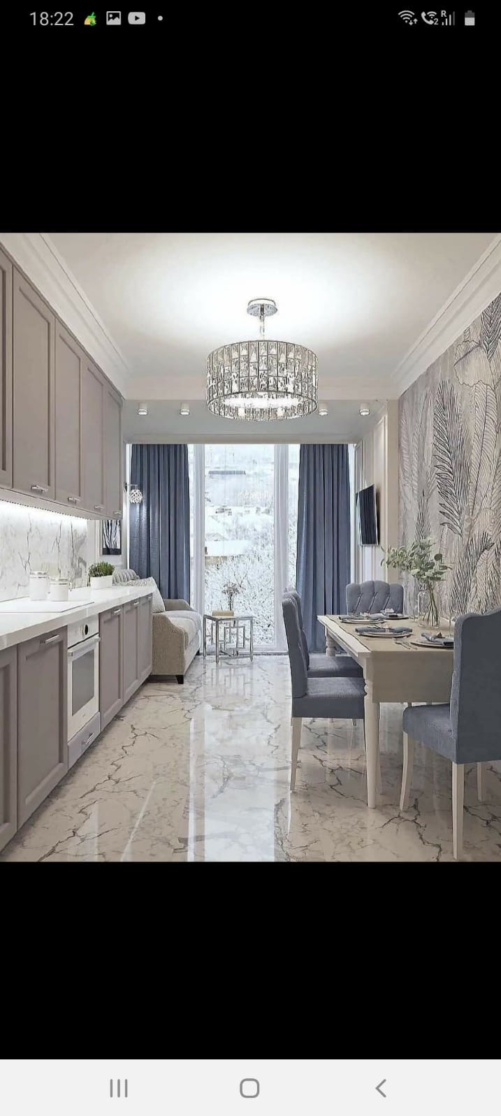 Jasne wnętrze z marmurową podłogą, szarymi meblami kuchennymi i jadalnianymi, kryształowym żyrandolem i tapetą w liście.
