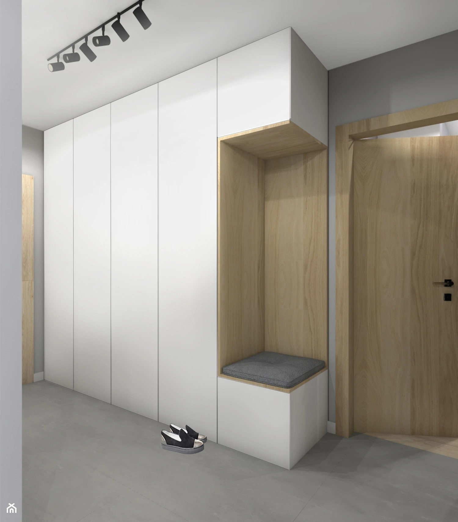 Biała szafa wnękowa z siedziskiem obok drewnianych drzwi, oświetlenie sufitowe punktowe, na podłodze leżą buty.
