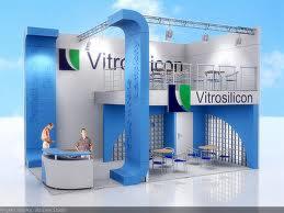 Wizualizacja stoiska targowego z niebiesko-białą kolorystyką, dwupiętrowa konstrukcja z logo firmy Vitrosilicon, oświetlenie metalowe, dwie osoby wewnątrz, błękitne tło nieba.