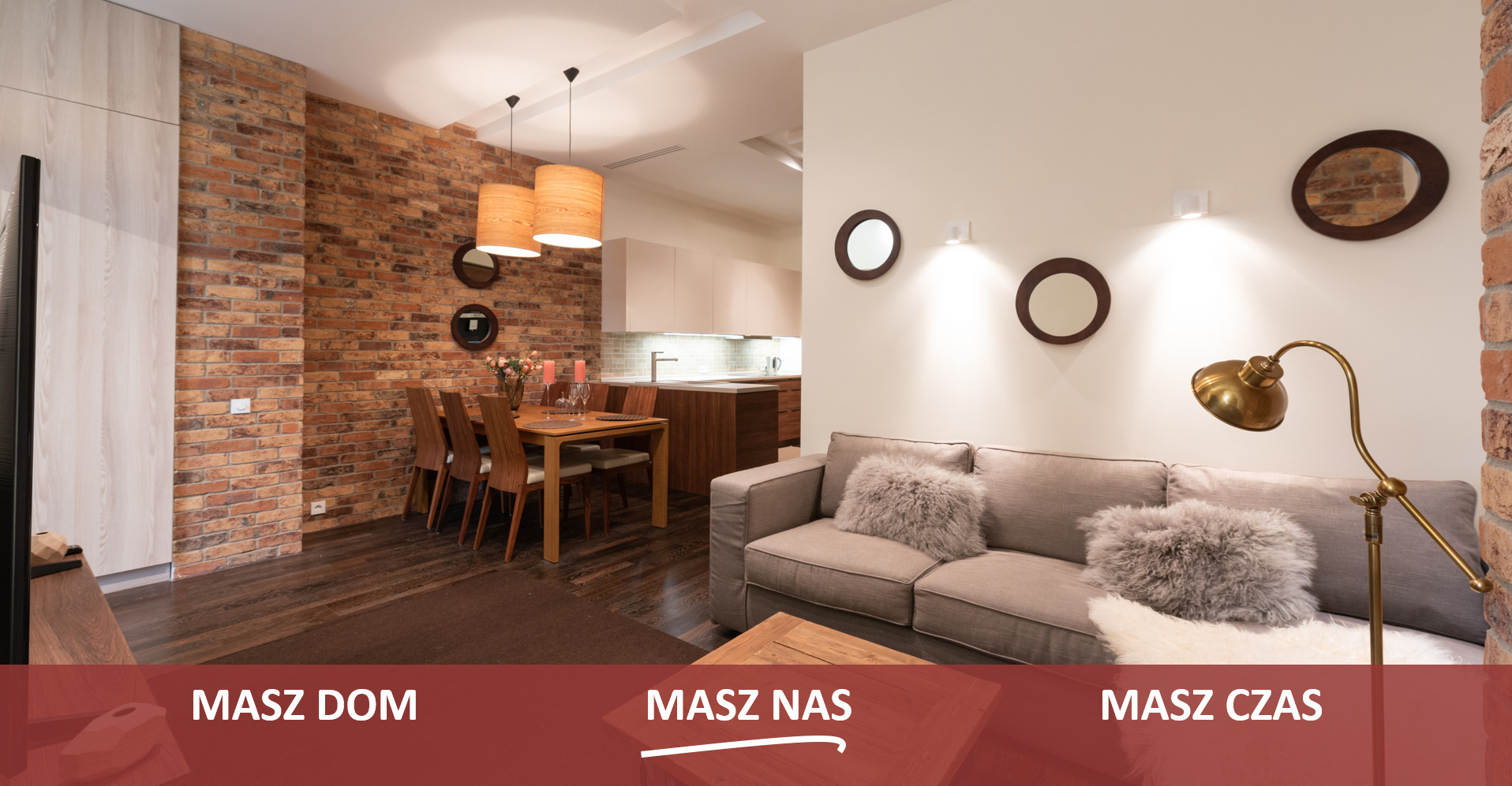 Jasne, przestronne wnętrze mieszkania z ceglaną ścianą, drewnianym stołem i szarym narożnikiem, oświetlone lampami wiszącymi i podłogowymi w stylu retro.