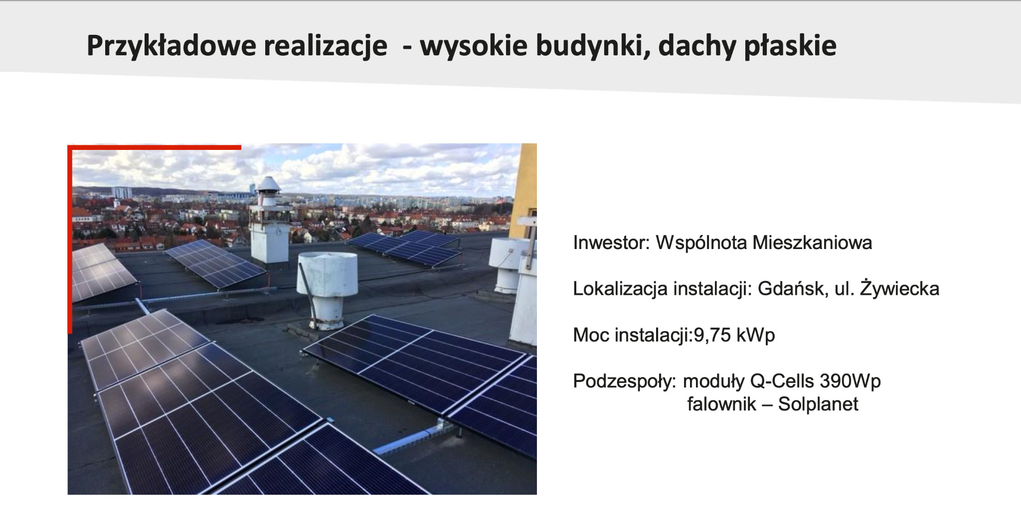 Instalacja paneli słonecznych Q-Cells 390Wp na płaskim dachu wysokiego budynku w Gdańsku, widok z góry na miasto w tle.
