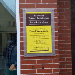 KANCELARIA DORADCY PODATKOWEGO BIURO RACHUNKOWE Paweł Kruszyński - Tablica informacyjna na ceglanej ścianie z nazwą: Kancelaria Doradcy Podatkowego Biuro Rachunkowe, imieniem i nazwiskiem doradcy, numerem wpisu, godzinami otwarcia, numerami telefonów i adresem...