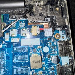 Leo Serwis Montaż i Demontaż - Wnętrze otwartego laptopa Lenovo z widoczną płytą główną, zdemontowaną klawiaturą i śladami kurzu, w trakcie wymiany lub naprawy.