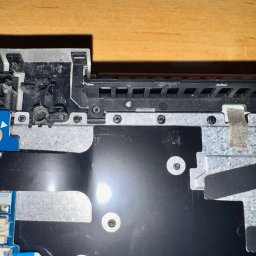 Leo Serwis Montaż i Demontaż - Wnętrze laptopa Lenovo w trakcie wymiany klawiatury nitowanej w Gdyni, widoczne elementy płyty głównej, metalowa obudowa i śruby mocujące.