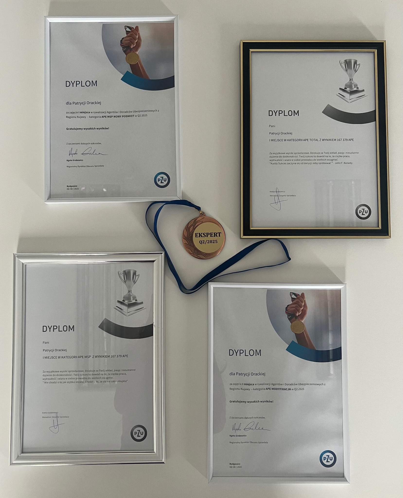 Dyplomy i medal 'Ekspert Q2/2025' na ścianie, nagrody dla Patrycji Orackiej, agenta ubezpieczeniowego. Uznanie za wyniki w PZU, gratulacje i wysokie wyniki.