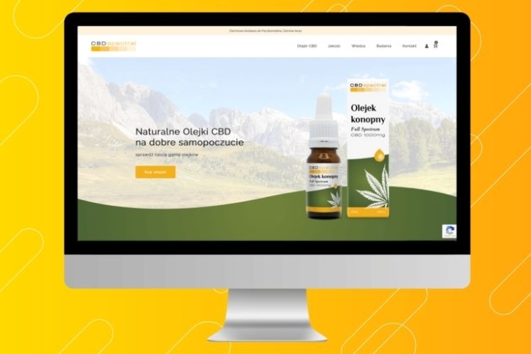 Ekran monitora prezentujący stronę internetową z ofertą naturalnych olejków CBD, z widocznym produktem na tle górskiego krajobrazu.