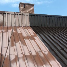 Pro-Dach - Częściowo pomalowany blaszany dach z ceglanym kominem w tle, ukazujący różnicę koloru przed i po malowaniu.