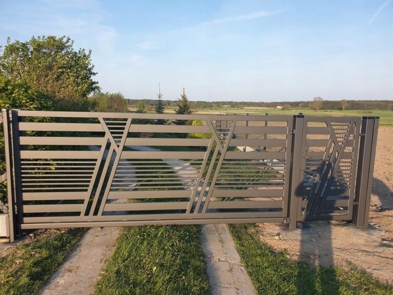 Nowoczesna, przesuwna brama wjazdowa z metalu w kolorze szarym, z poziomymi profilami i ukośnymi wzmocnieniami, na tle zieleni i nieba.