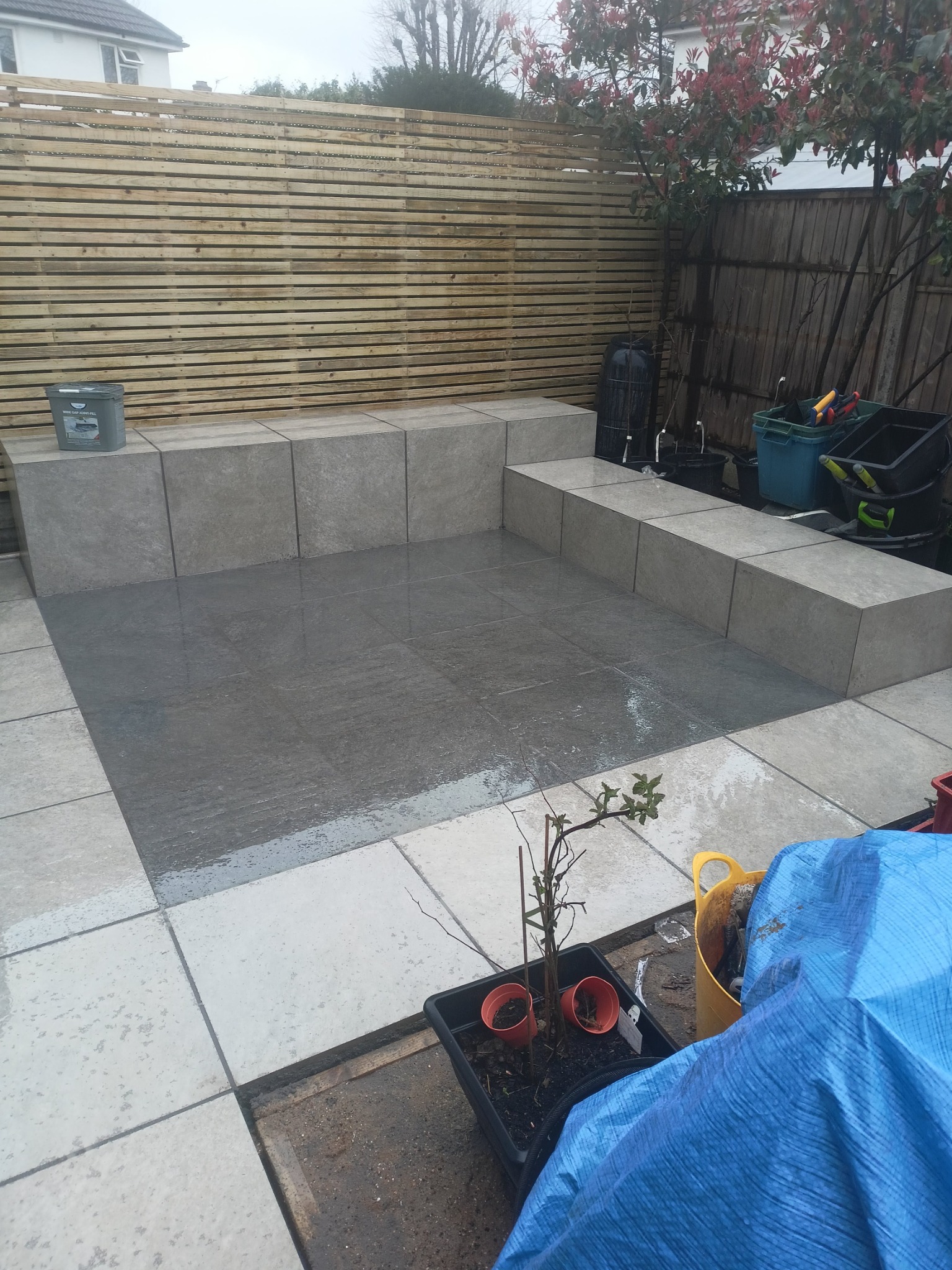 Wykonanie tarasu ogrodowego z siedzeniami z płytek gresowych.