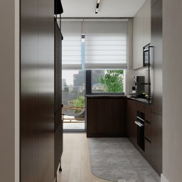 Architekt wnętrz - Małgorzata Juszkiewicz - Nowoczesna kuchnia z drewnianymi frontami, szarą podłogą i wyjściem na balkon z widokiem na miasto. Minimalistyczne oświetlenie sufitowe i sprzęt AGD.