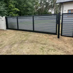 Nowoczesna, przesuwna brama posesyjna z poziomych, szarych paneli, osadzona w czarnej ramie, z widocznym numerem domu 66A w tle.