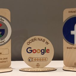 KANDAFI Michał Kansik - Drewniane standy z logo Google i Facebook z NFC do zbierania opinii. Napisy: 'Zbliż telefon, zostaw ocenę', 'Dołącz do nas, bądź na bieżąco'.