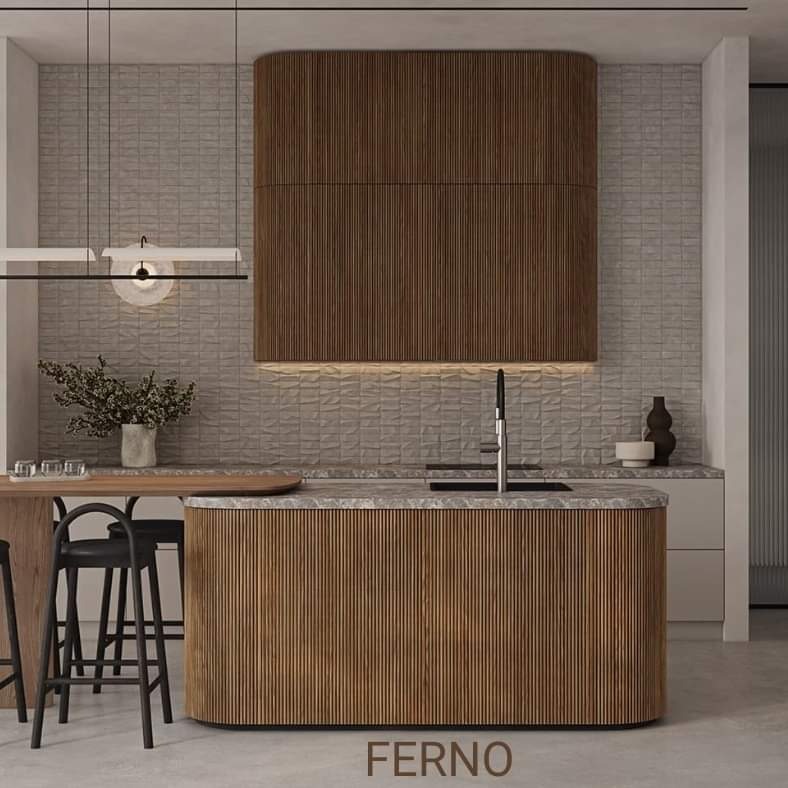 Nowoczesna kuchnia z wyspą o zaokrąglonych krawędziach, wykończona pionowymi listwami z drewna, z blatem z szarego kamienia. Nad wyspą wisi drewniany okap, a w tle widać teksturowaną ścianę...