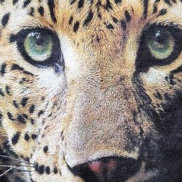 drukenhaft - Fragment koszulki z nadrukiem zbliżenia pyska geparda z intensywnie zielonymi oczami.