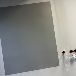 RBK Construction - Fragment ściany pomalowanej na dwa odcienie szarości, z widoczną instalacją elektryczną w trakcie montażu gniazdek.