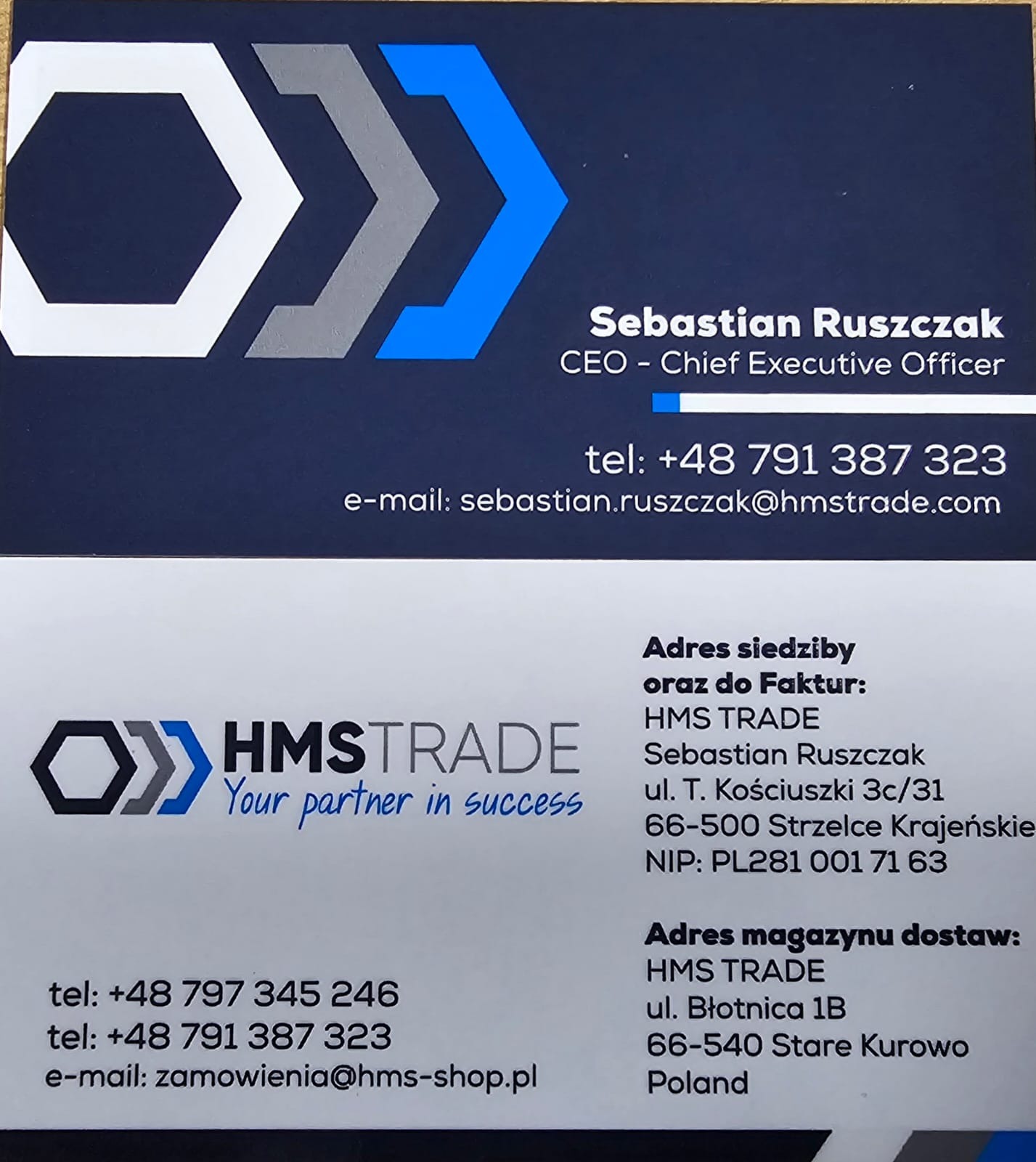 Wizytówka firmy HMS TRADE z logo w kształcie trzech strzałek w kolorach białym, szarym i niebieskim, zawierająca dane kontaktowe CEO Sebastiana Ruszczaka oraz adresy siedziby i magazynu.